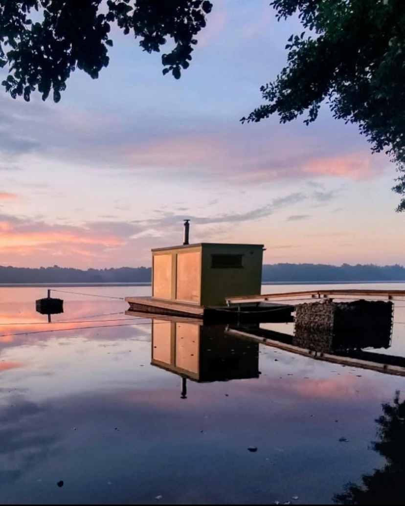 Flytande bastu i solnedgång vid sjön Möckeln